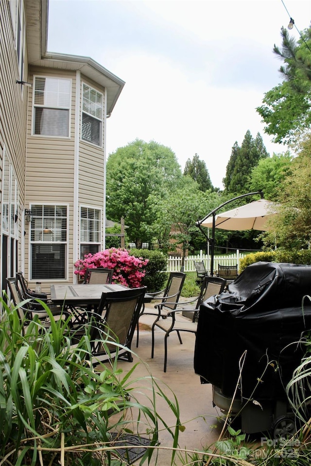 view of patio / terrace featuring grilling area, fence, and outdoor dining space