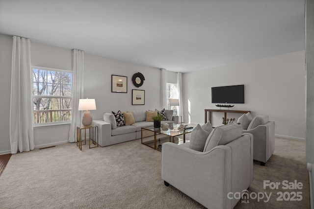 living room with visible vents, a wealth of natural light, carpet floors, and baseboards