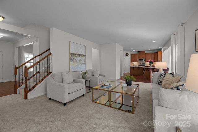 living room featuring stairway, recessed lighting, baseboards, and light carpet