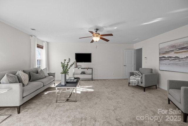 carpeted living area with ceiling fan and baseboards