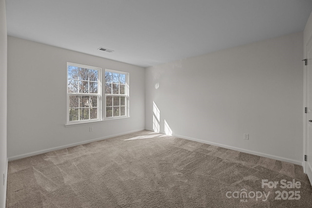 carpeted empty room with visible vents and baseboards
