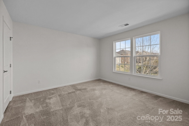 carpeted spare room featuring visible vents and baseboards