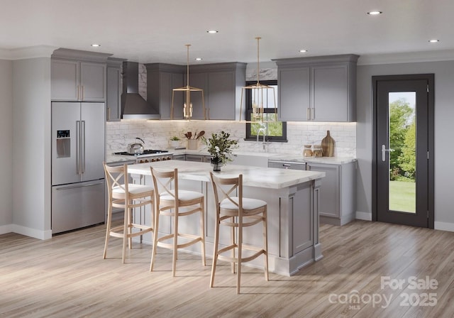 kitchen with a sink, wall chimney range hood, stainless steel appliances, and gray cabinets