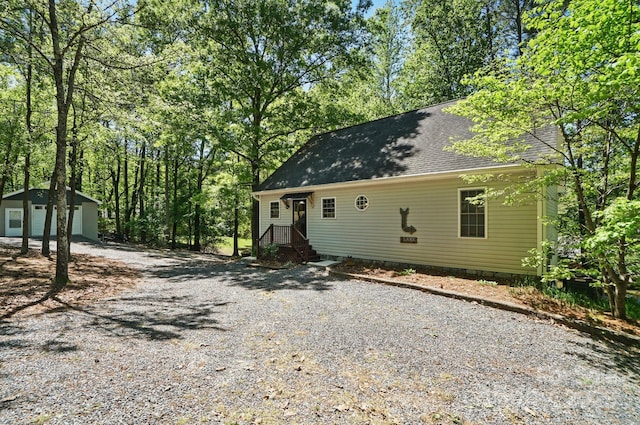 9711 Pine Tree Rd, Norwood, NC 28128 - view of front of home with gravel driveway, a shingled roof, and an outbuilding