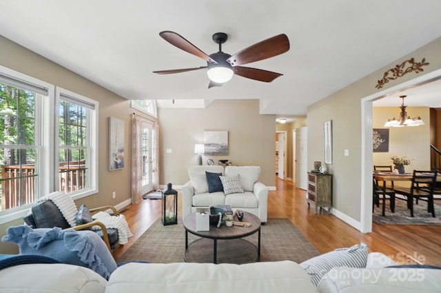 9711 Pine Tree Rd, Norwood, NC 28128 - living room with light wood finished floors, baseboards, and ceiling fan with notable chandelier