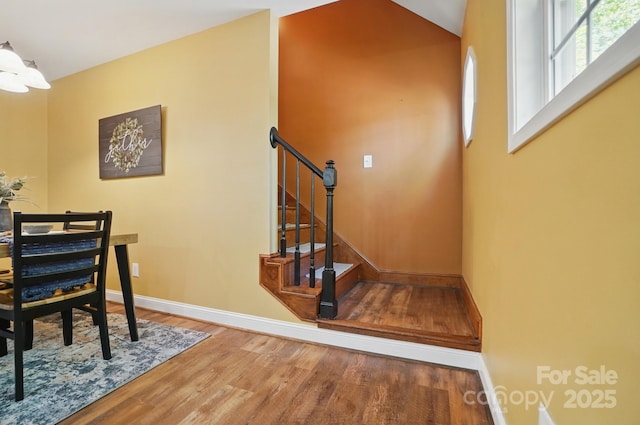 9711 Pine Tree Rd, Norwood, NC 28128 - stairs featuring wood finished floors, baseboards, and an inviting chandelier