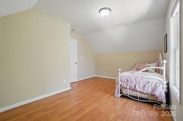 9711 Pine Tree Rd, Norwood, NC 28128 - bedroom with vaulted ceiling, light wood finished floors, visible vents, and baseboards
