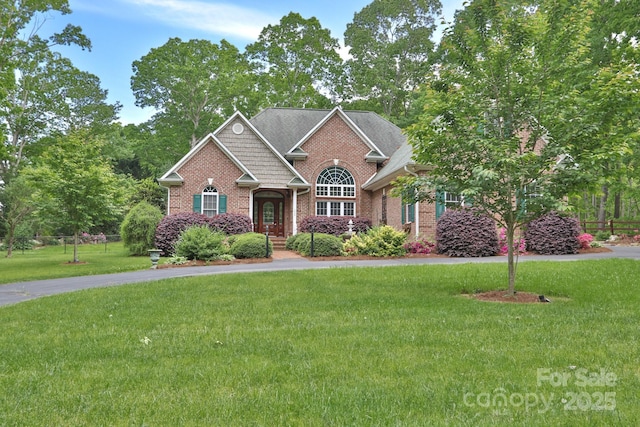 craftsman-style home with a front yard and brick siding