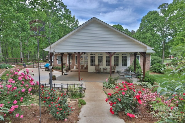 back of property featuring brick siding, fence, and a patio area
