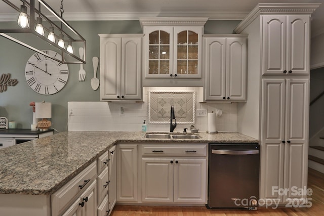 kitchen featuring stone countertops, tasteful backsplash, dishwasher, and a sink