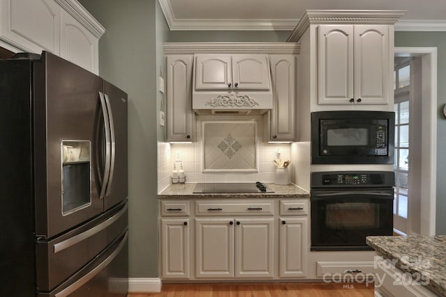 kitchen with crown molding, black appliances, light stone countertops, and tasteful backsplash