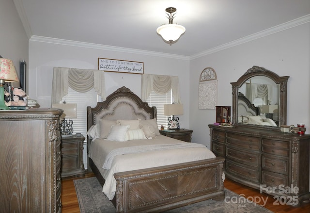 bedroom with ornamental molding and wood finished floors