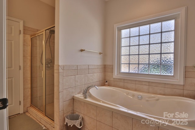 bathroom featuring a garden tub and a shower stall