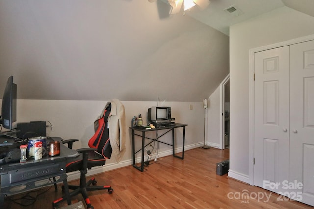office space featuring baseboards, wood finished floors, ceiling fan, and vaulted ceiling