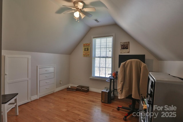 office with light wood-style floors, a ceiling fan, visible vents, vaulted ceiling, and baseboards