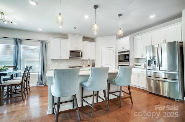 4337 Duplin Dr, Charlotte, NC 28214 - kitchen featuring light countertops, backsplash, visible vents, appliances with stainless steel finishes, and wood finished floors