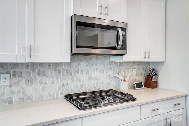 4337 Duplin Dr, Charlotte, NC 28214 - kitchen featuring white cabinets, light stone countertops, appliances with stainless steel finishes, and decorative backsplash