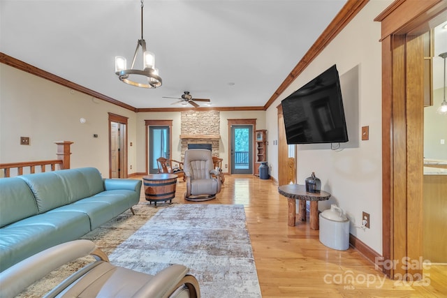 298 Poplar Grove Ct, Taylorsville, NC 28681 - living room featuring crown molding, a fireplace, baseboards, light wood-type flooring, and ceiling fan with notable chandelier