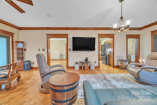 298 Poplar Grove Ct, Taylorsville, NC 28681 - living room featuring light wood finished floors, ceiling fan with notable chandelier, baseboards, visible vents, and ornamental molding