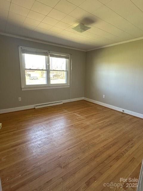 unfurnished room featuring a baseboard radiator, ornamental molding, and wood finished floors