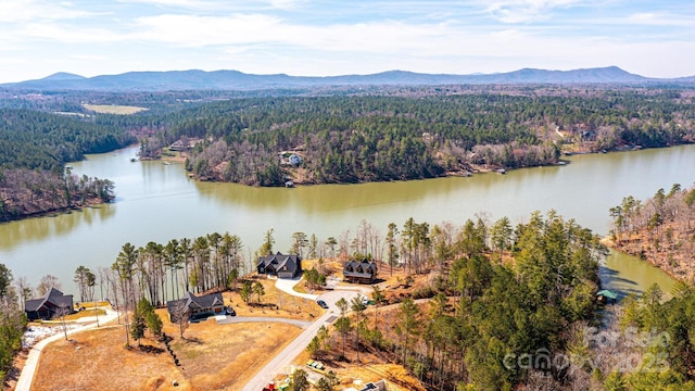 aerial view with a wooded view and a water and mountain view