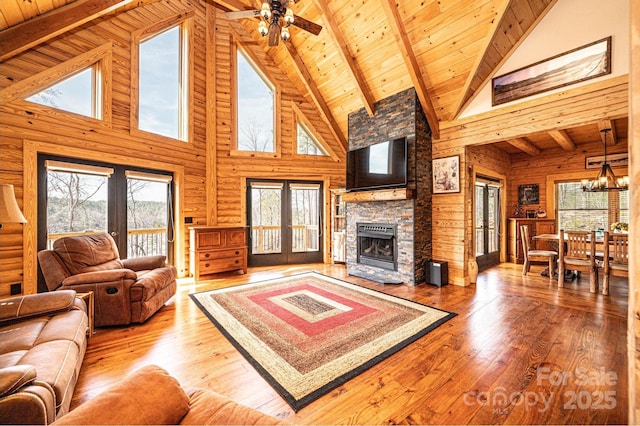 living room with a fireplace, beamed ceiling, high vaulted ceiling, hardwood / wood-style flooring, and wooden ceiling