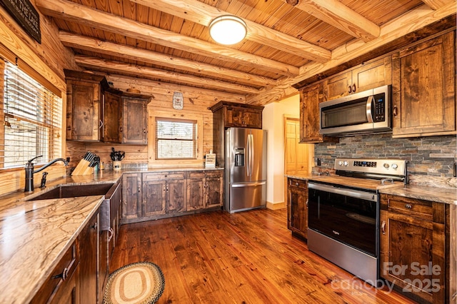 kitchen with beamed ceiling, wooden ceiling, a sink, appliances with stainless steel finishes, and backsplash