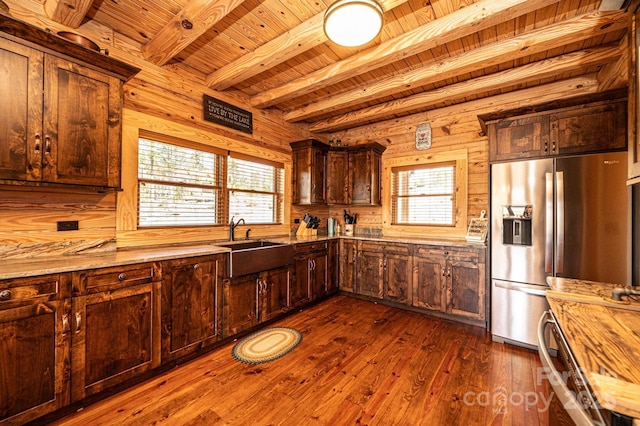 kitchen with beamed ceiling, dark wood-style floors, stainless steel fridge, wooden ceiling, and a sink