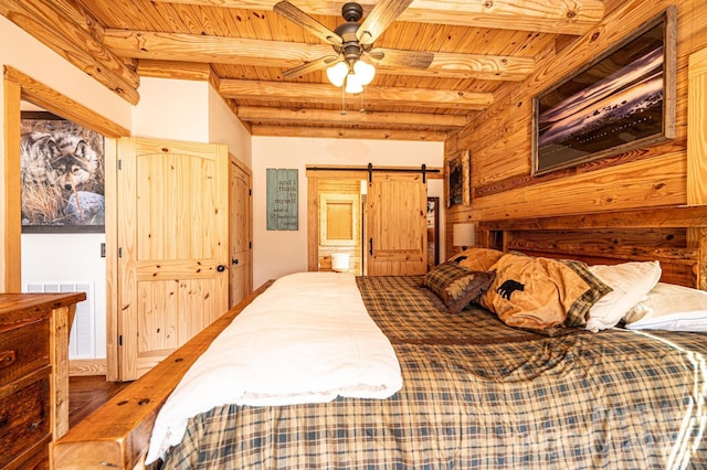 bedroom featuring visible vents, beamed ceiling, a barn door, wood ceiling, and ensuite bath