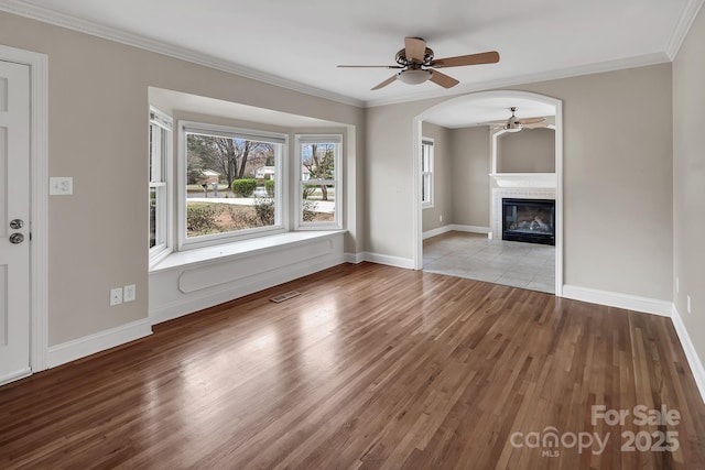 403 Hillcrest Dr, Huntersville, NC 28078 - unfurnished living room featuring a tiled fireplace, wood finished floors, ornamental molding, and a ceiling fan