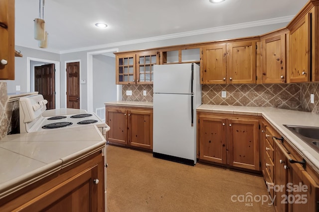 403 Hillcrest Dr, Huntersville, NC 28078 - kitchen with crown molding, light countertops, light floors, brown cabinets, and white appliances
