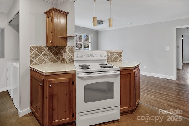 403 Hillcrest Dr, Huntersville, NC 28078 - kitchen with white electric range oven, tile counters, ornamental molding, brown cabinetry, and washer and clothes dryer
