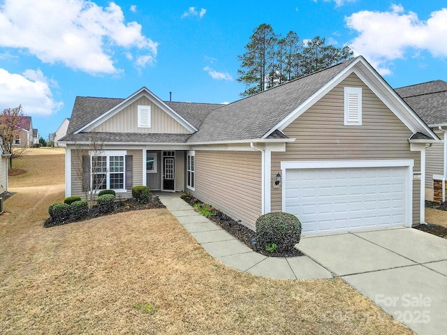view of front of home featuring concrete driveway, a shingled roof, and a front lawn