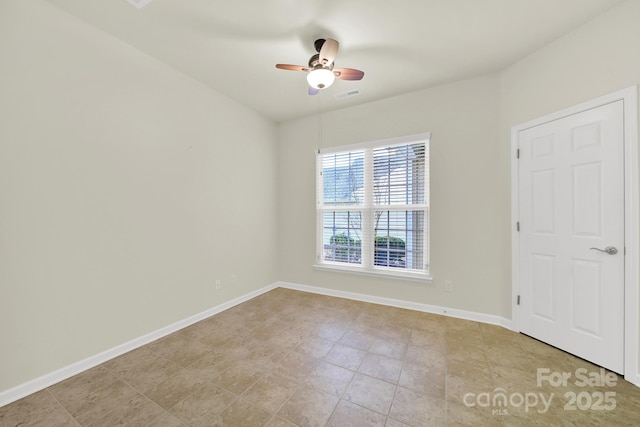 empty room with baseboards, visible vents, and a ceiling fan