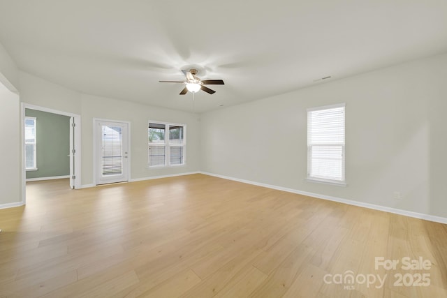 spare room with a ceiling fan, baseboards, and light wood-style flooring