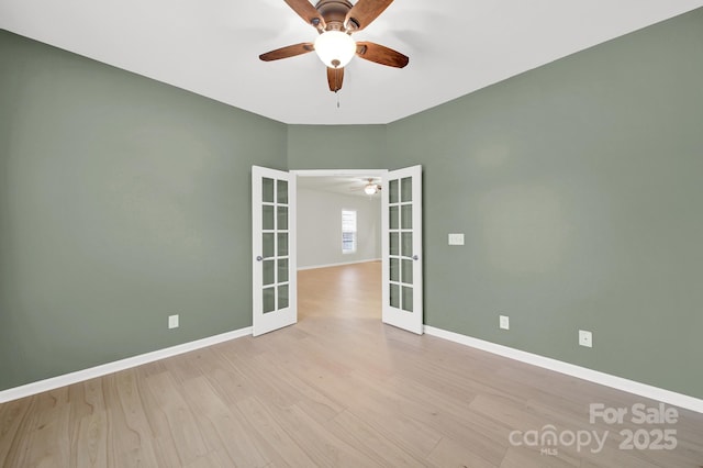 unfurnished room featuring baseboards, ceiling fan, wood finished floors, and french doors