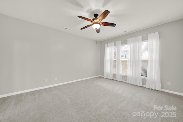 empty room featuring carpet flooring, a ceiling fan, baseboards, and visible vents