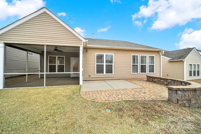 back of property featuring a lawn, a sunroom, roof with shingles, and a patio area