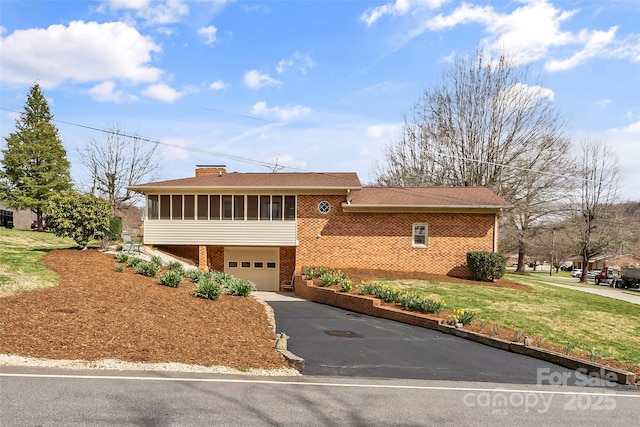 3829 Norman Rd, Morganton, NC 28655 - view of front of home featuring a front yard, brick siding, aphalt driveway, a sunroom, and a garage
