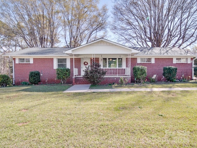 ranch-style home featuring a porch, brick siding, and a front yard