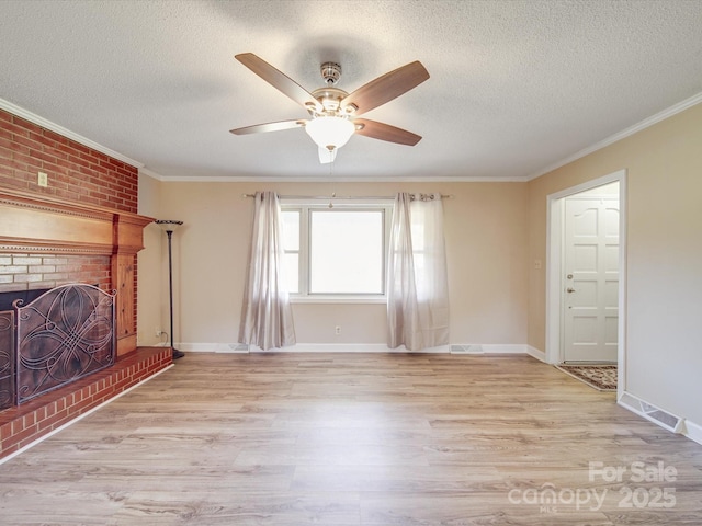 unfurnished living room with light wood-style flooring, a brick fireplace, ornamental molding, and ceiling fan