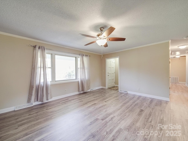 unfurnished room with visible vents, ornamental molding, light wood-type flooring, and a ceiling fan