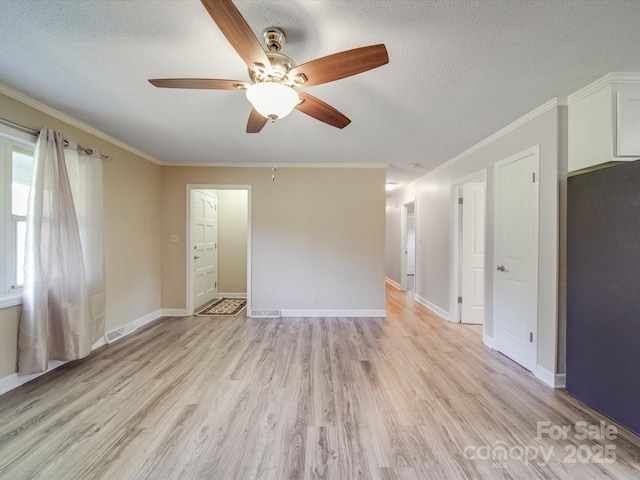 empty room with a ceiling fan, a textured ceiling, visible vents, light wood-style floors, and ornamental molding