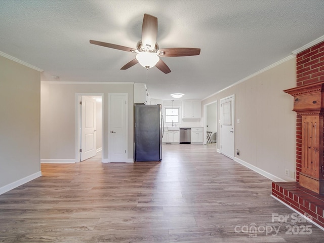 unfurnished living room featuring light wood-type flooring, crown molding, ceiling fan, and a sink