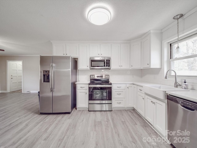 kitchen with white cabinetry, light wood-style flooring, a sink, and appliances with stainless steel finishes