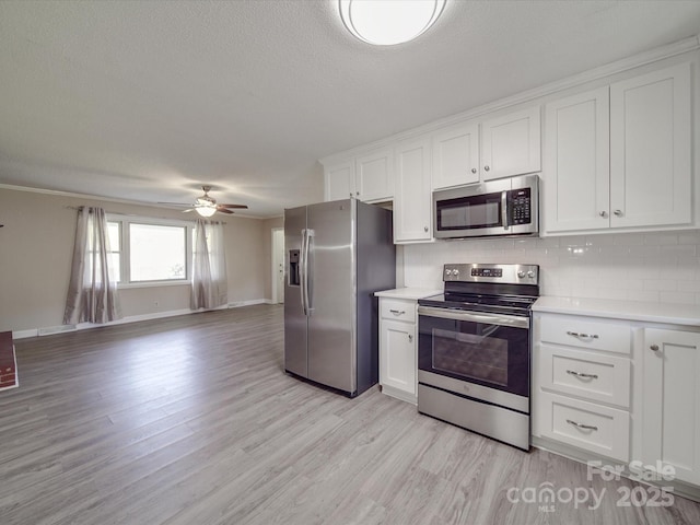 kitchen with a ceiling fan, open floor plan, light countertops, and stainless steel appliances