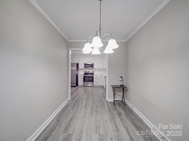 corridor featuring baseboards, ornamental molding, and a chandelier
