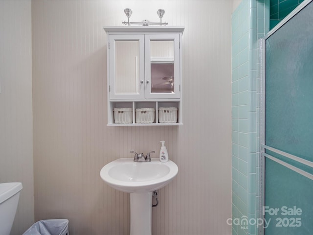 bathroom featuring a stall shower and toilet