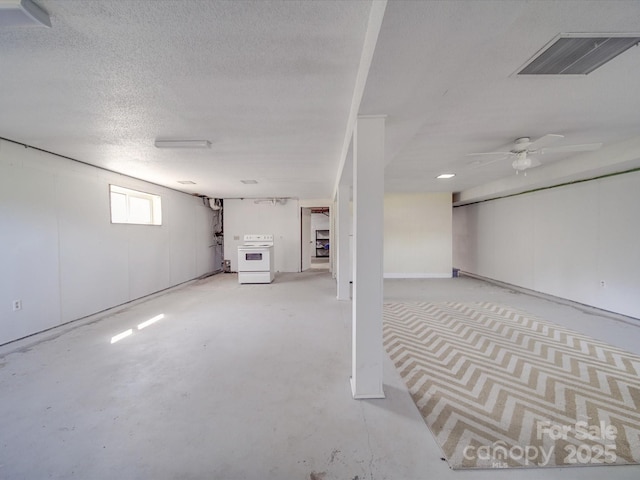 basement with visible vents, a ceiling fan, and a textured ceiling