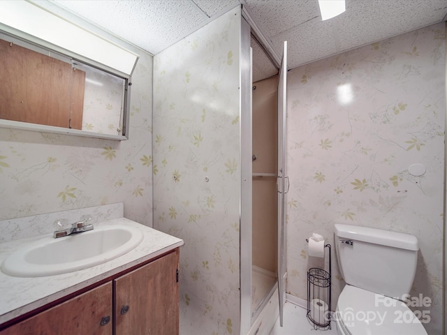 full bathroom with a stall shower, wallpapered walls, toilet, and vanity